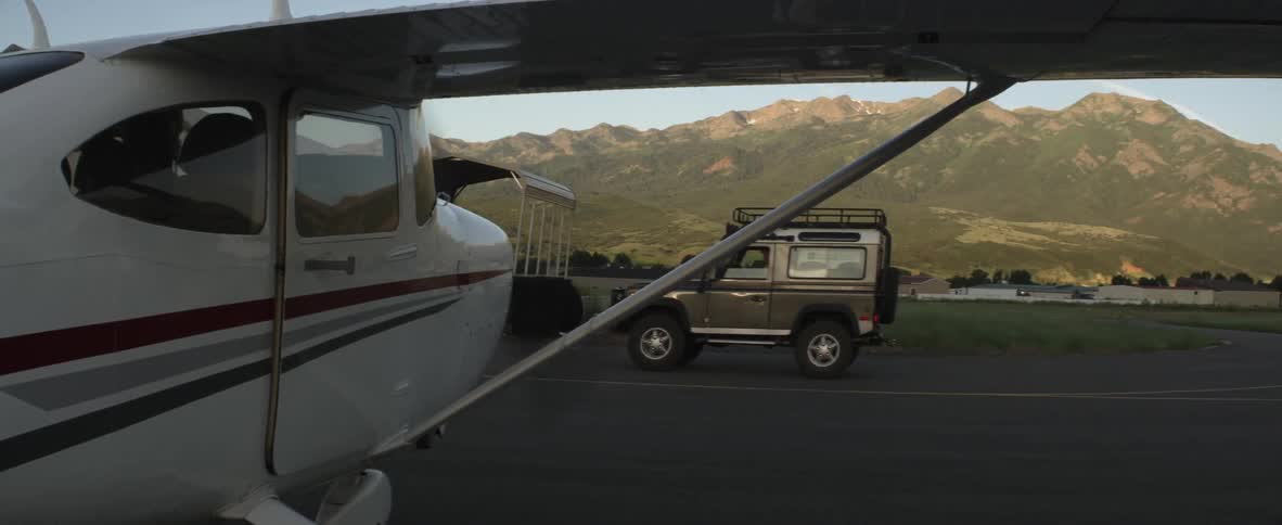 A jeep drives past a plane