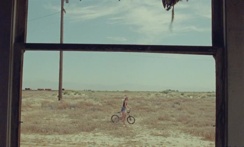 A woman walks her bike outside