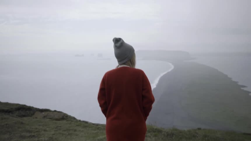 A woman in a red shirt walks down a hill