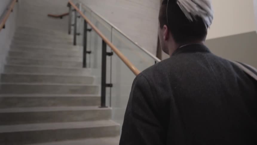 A man ascends a concrete staircase