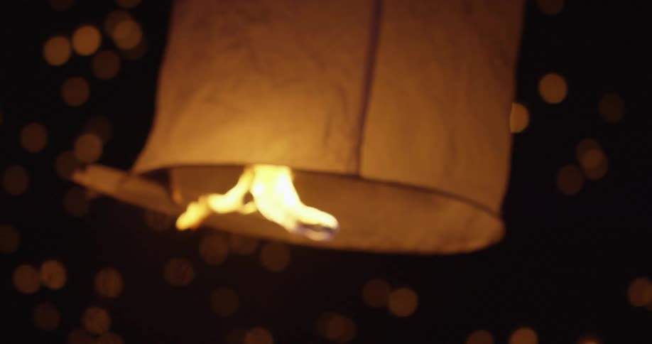 People light and release paper lanterns
