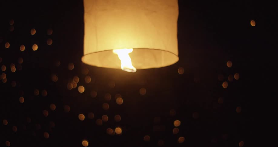 People releasing paper lanterns into the sky