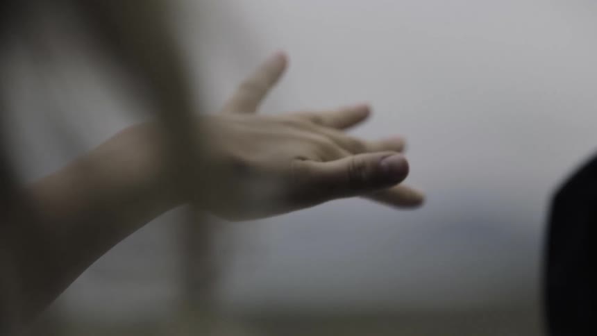 A person has his hand waving out of a window