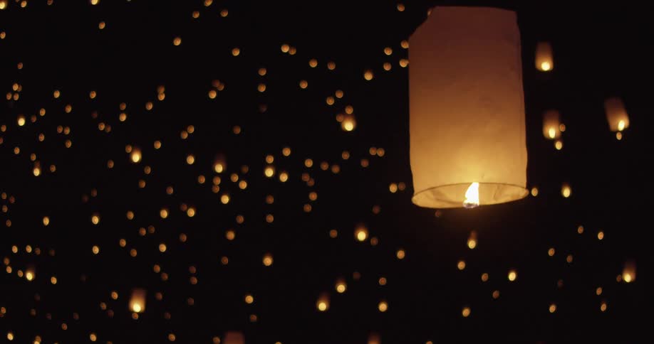 People light and release paper lanterns