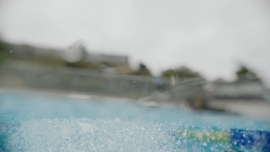 Small bubbles rise to the surface of clear blue water