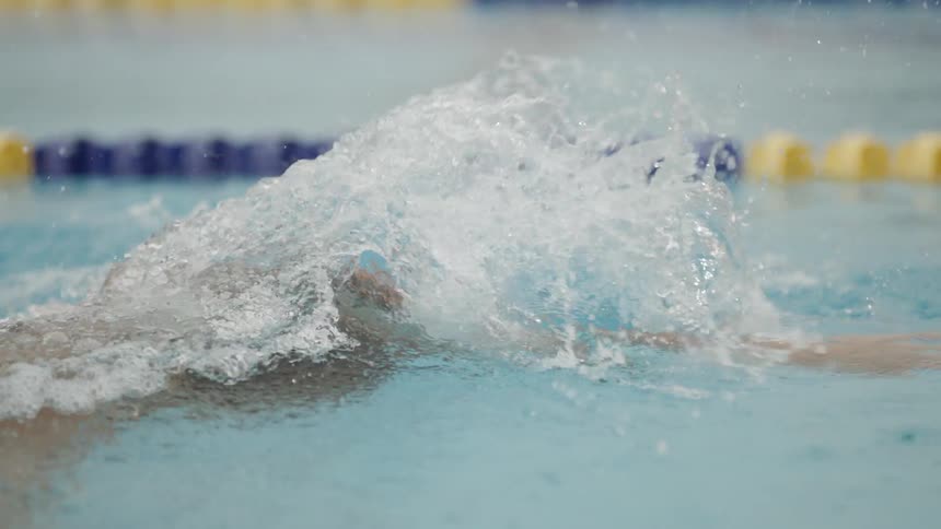 A person is swimming in a lap pool