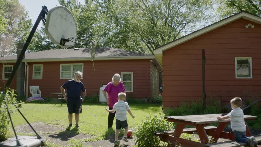 A family plays basketball together in the backyard