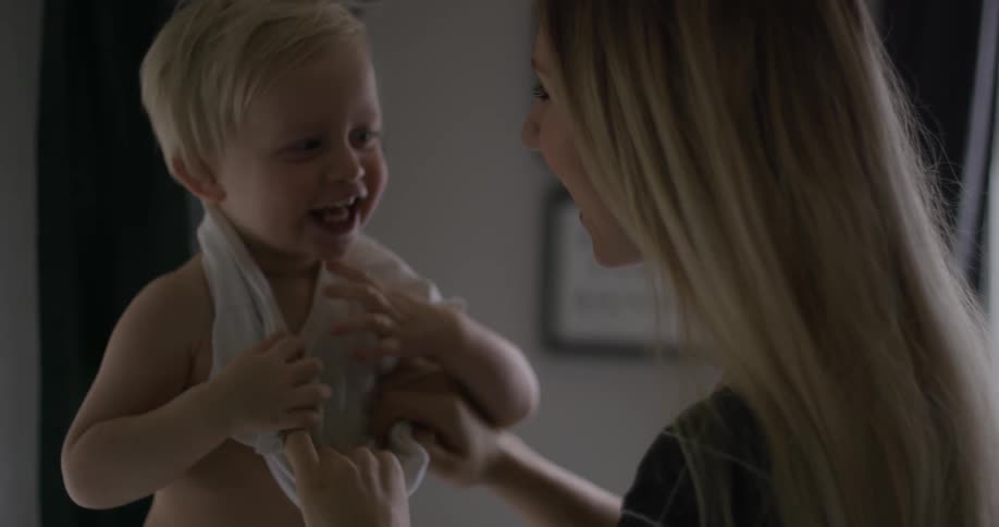 A woman is helping a child get dressed