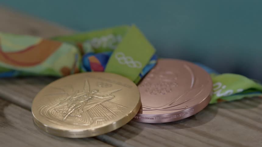 A gold and a bronze medal sit on a table