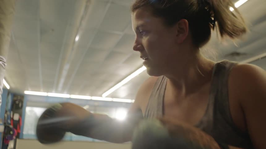 A woman punches and jabs the equipment