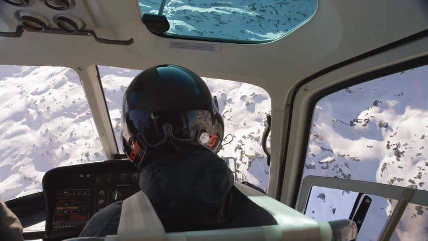 Pilot and passenger flying over the arctic in a helicopter