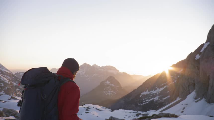 A person is hiking in a mountain area during winter