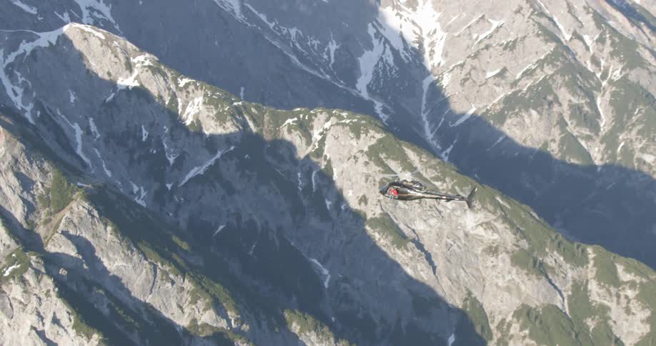 A helicopter flies over a mountain range