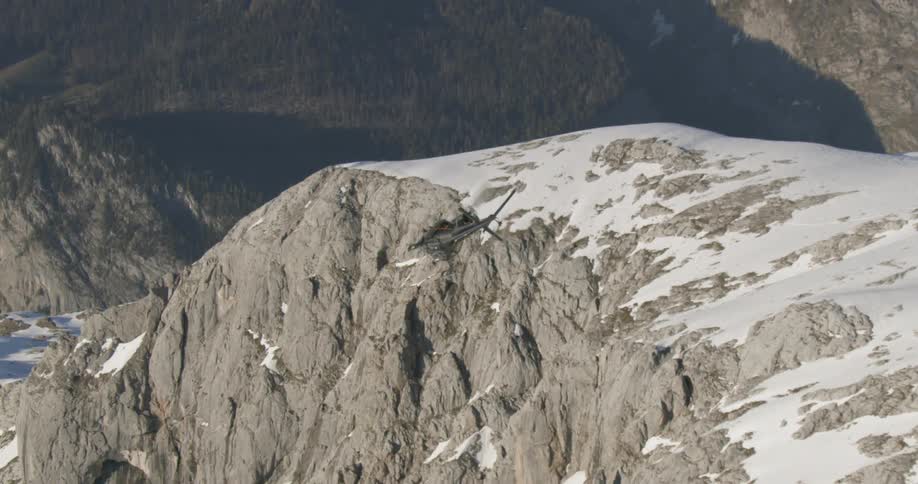 A helicopter is flying near some mountains