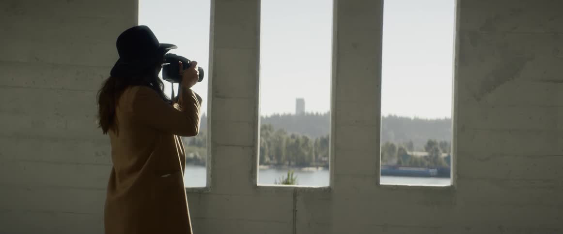 A photographer takes photos out a window