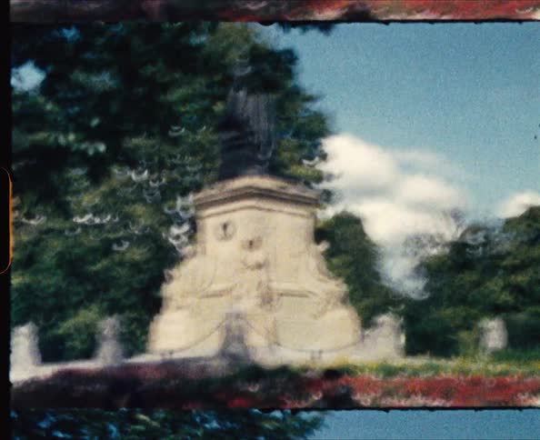 People sitting and walking around a monument in a park during the day