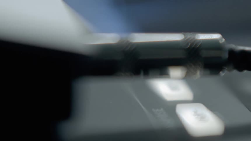 Close up of a person plugging in and unplugging an aux cable