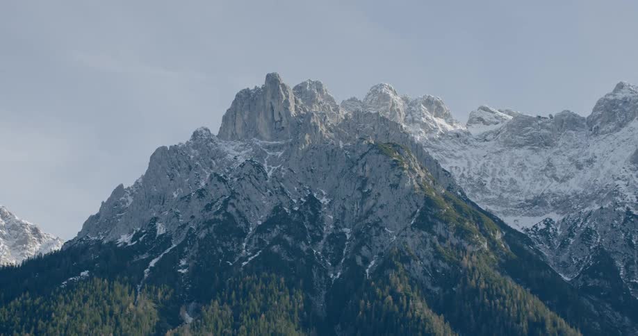 Snow covered mountains sit under the blue sky