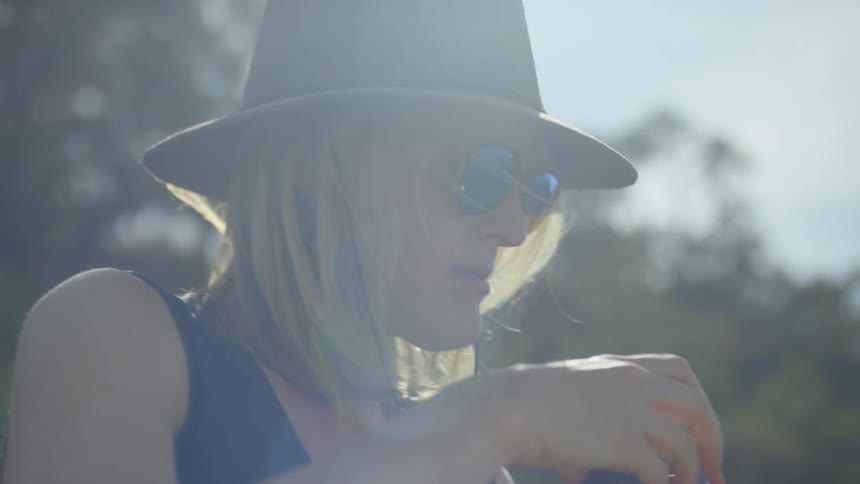 A woman in a hat sets up her easel and canvas to paint