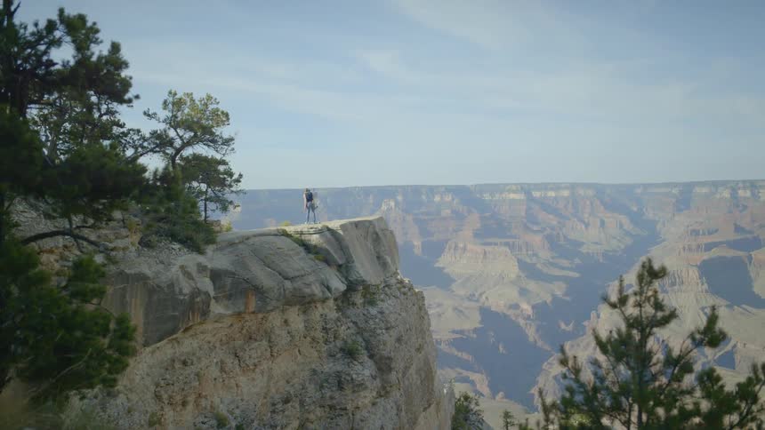 A person stands at the top of the cliff