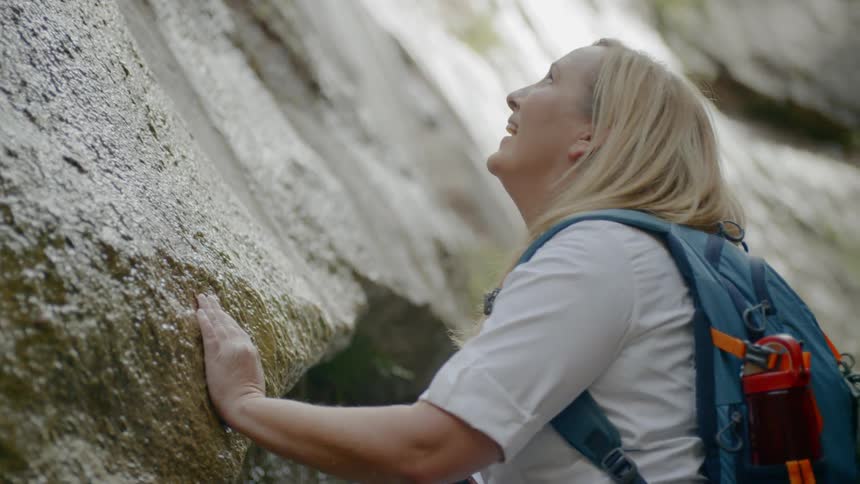 Woman at the base of a cliff