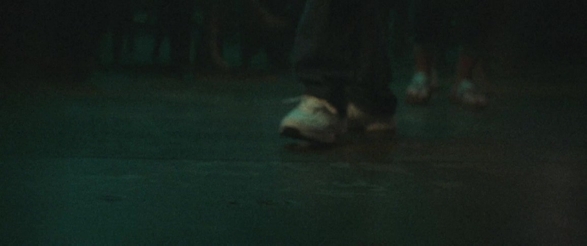 People stepping backwards in a dark room