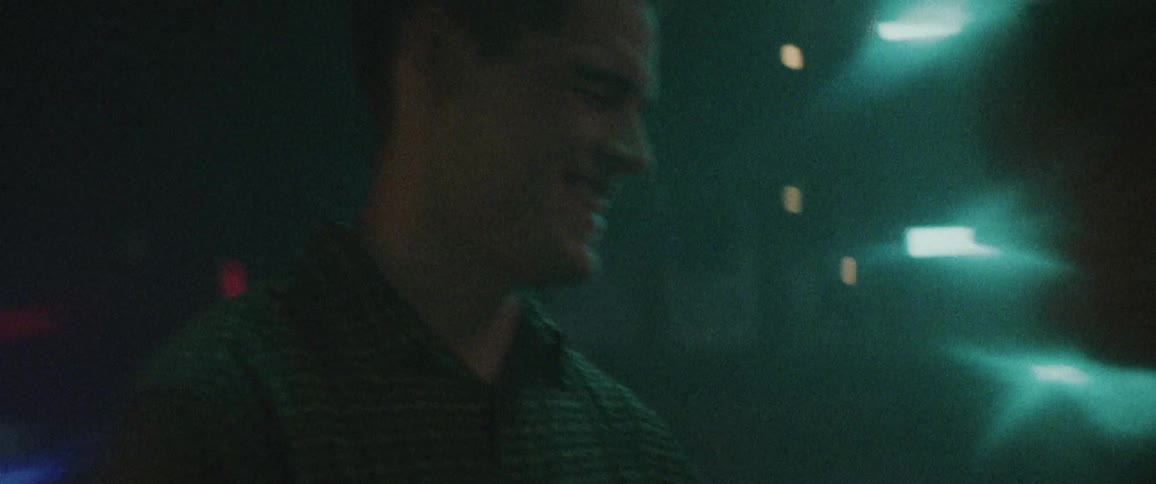 A man and woman laugh together in a night club