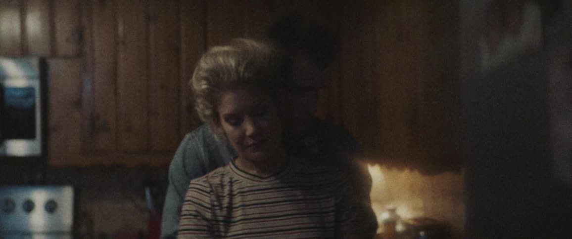 A man hugging a woman from behind in the kitchen