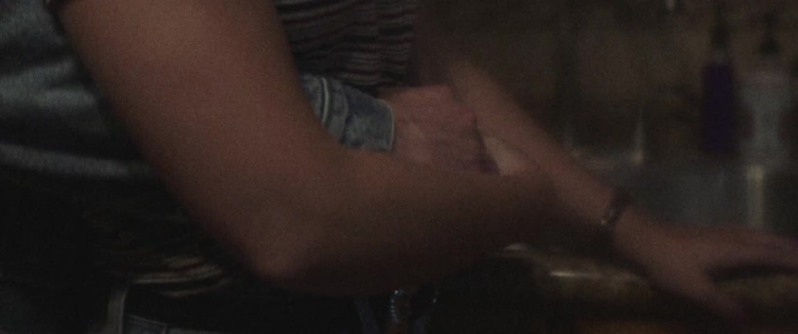 A man has his arms wrapped around a womans waist next to a kitchen sink