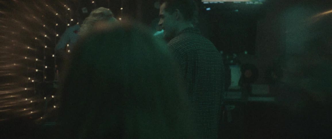 A man and a woman in a nightclub touching and talking