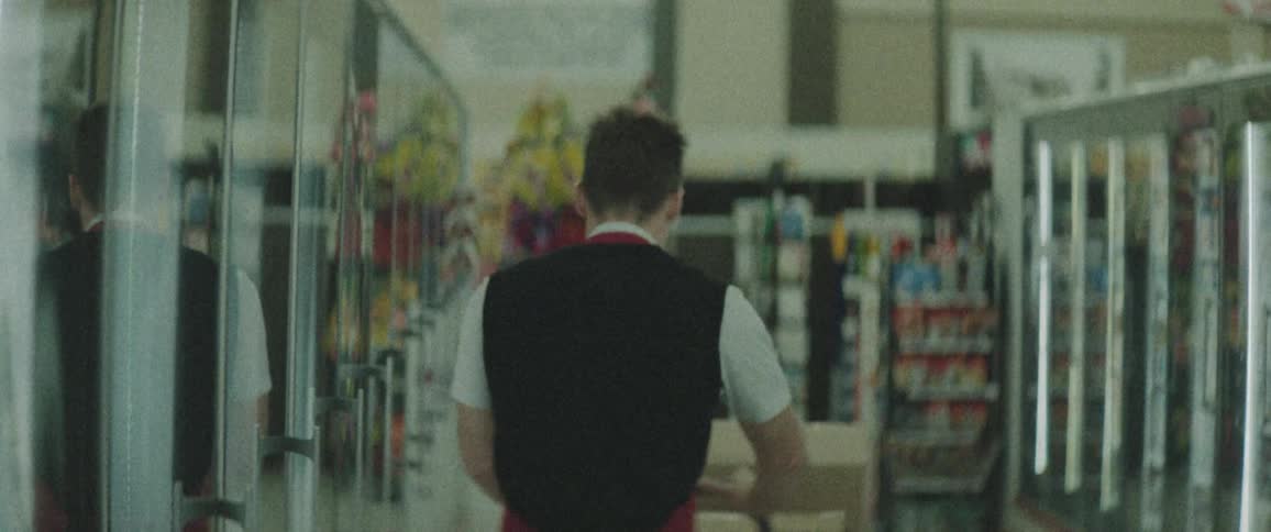A store employee pushes a cart of boxes down the aisle