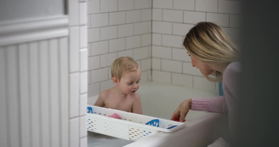A woman is bathing a baby