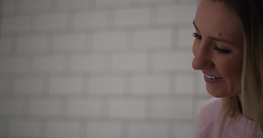 A woman is smiling as she looks down