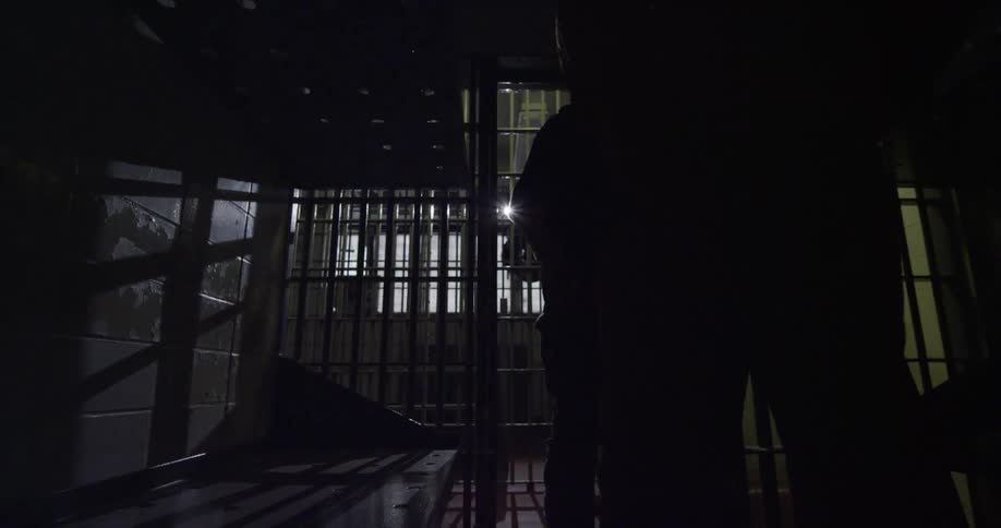 A prisoner walking towards a cell