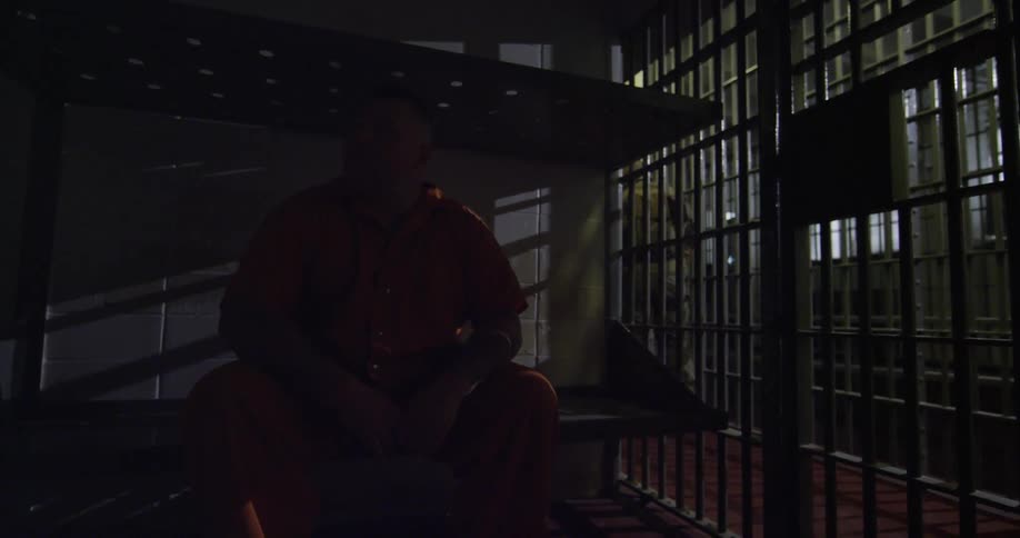 A guard closing the door of a man's cell