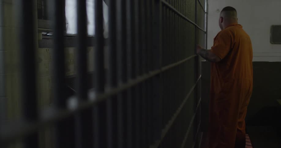 A prisoner walking towards a cell