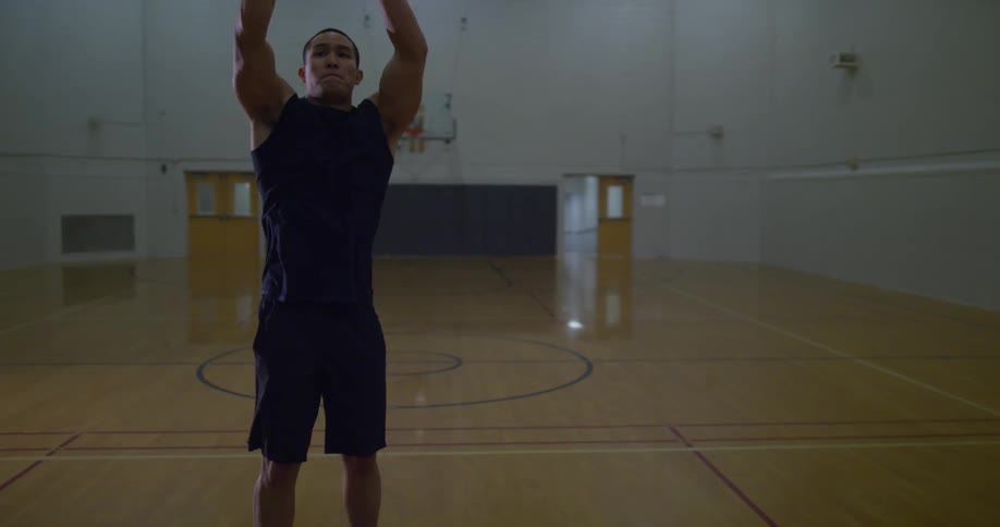 A man dribbles a basketball and goes for a shot