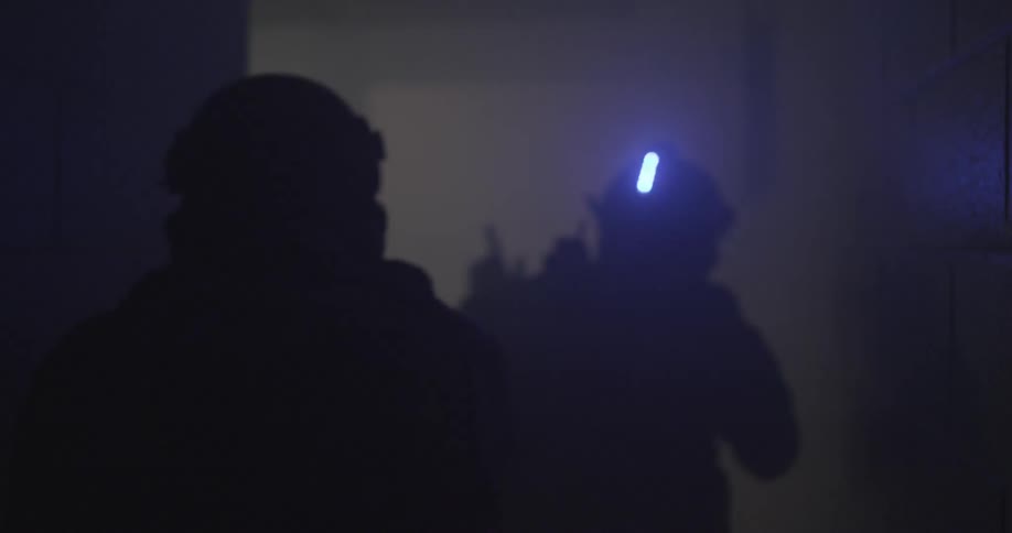 A swat team navigates a dark building