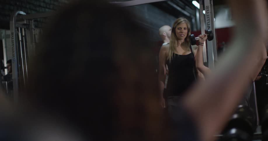 A woman lifts weights in a gym