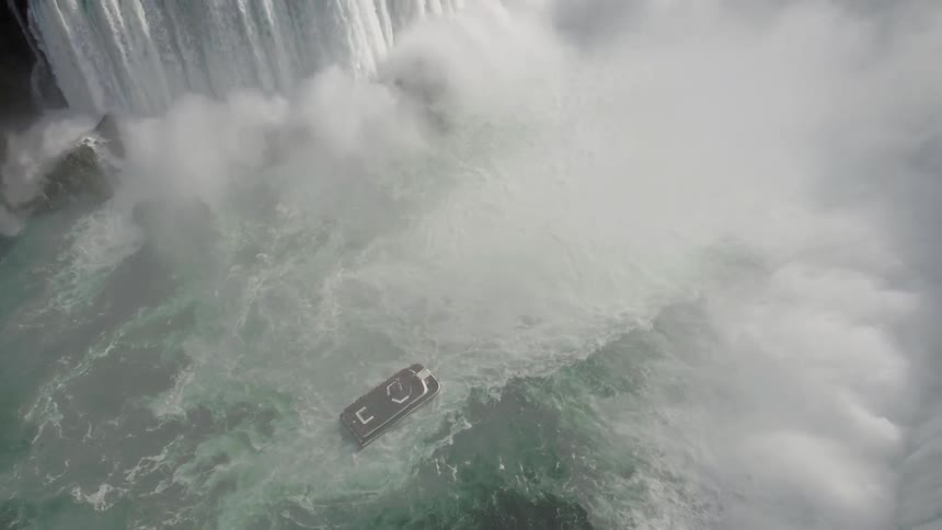 A boat sailing near a waterfall