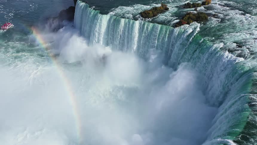 An aerial view of a waterfall with a rainbow