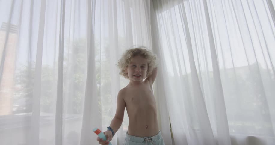 A little boy sets goggles and a snorkel onto a table