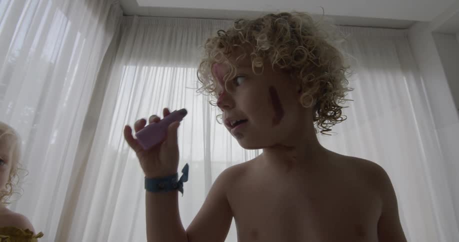 Toddlers playing with dolls and makeup in room