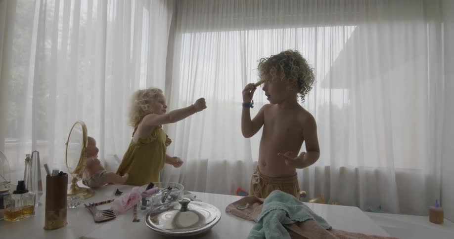 Two curly haired children play together