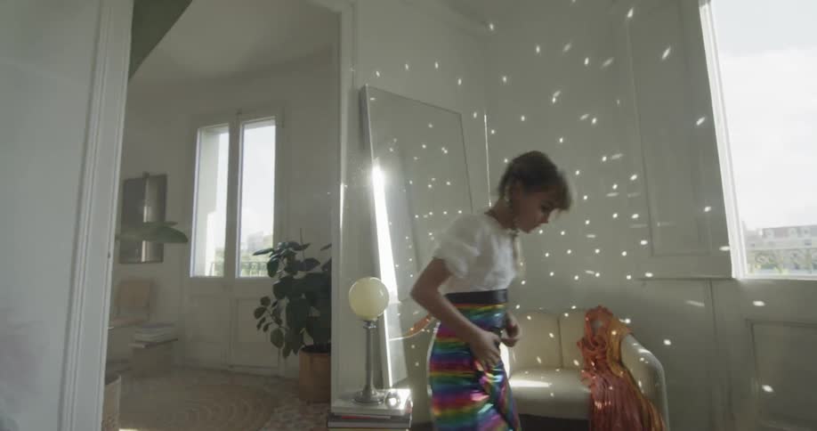 A young girl wraps material around her waist