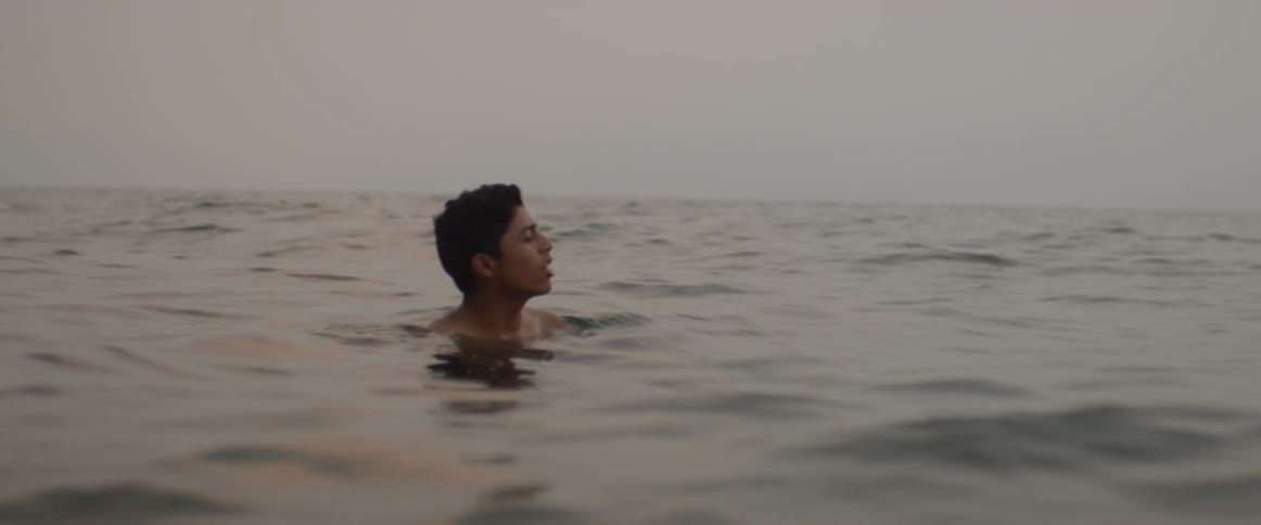 A young man relaxes in a lake