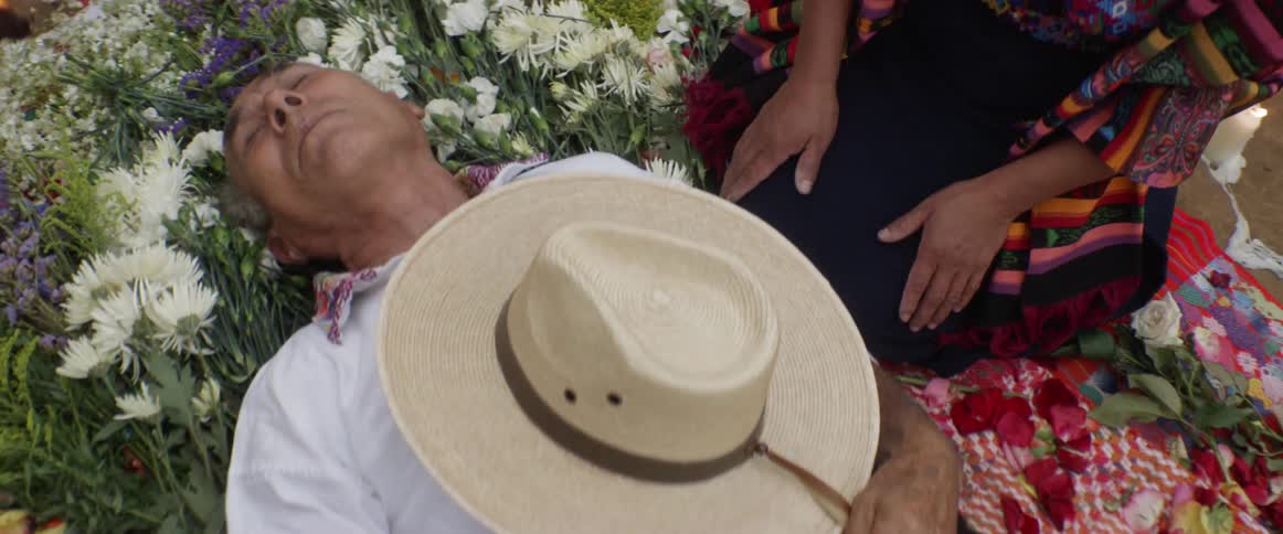 An old man dead above a flower bouquet