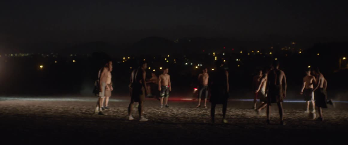 A group of man playing ball in the dark