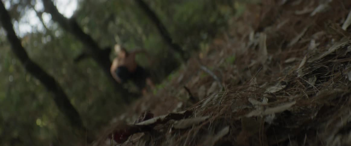 Person in loincloth and helmet running through woods