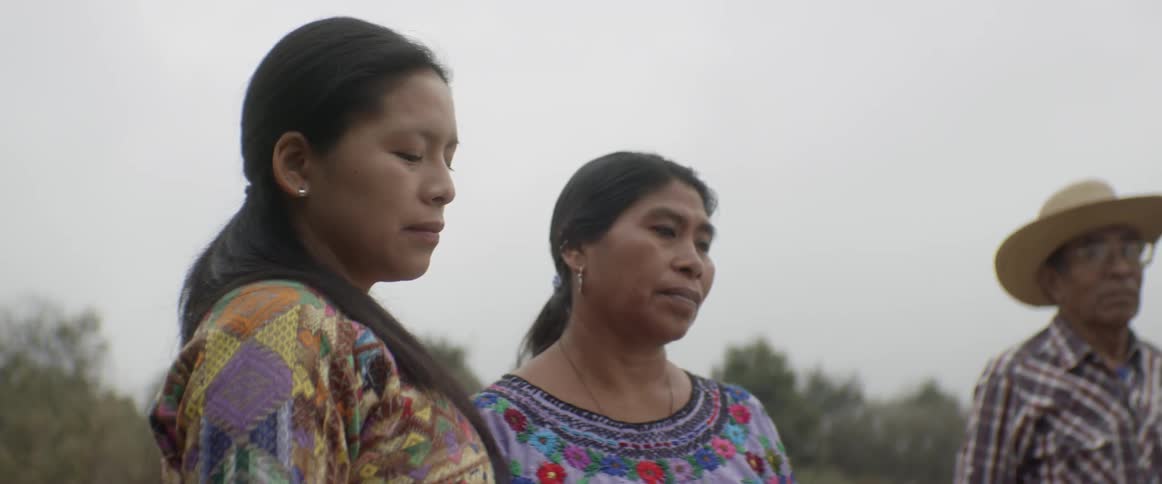 A group of people stand together with their eyes closed